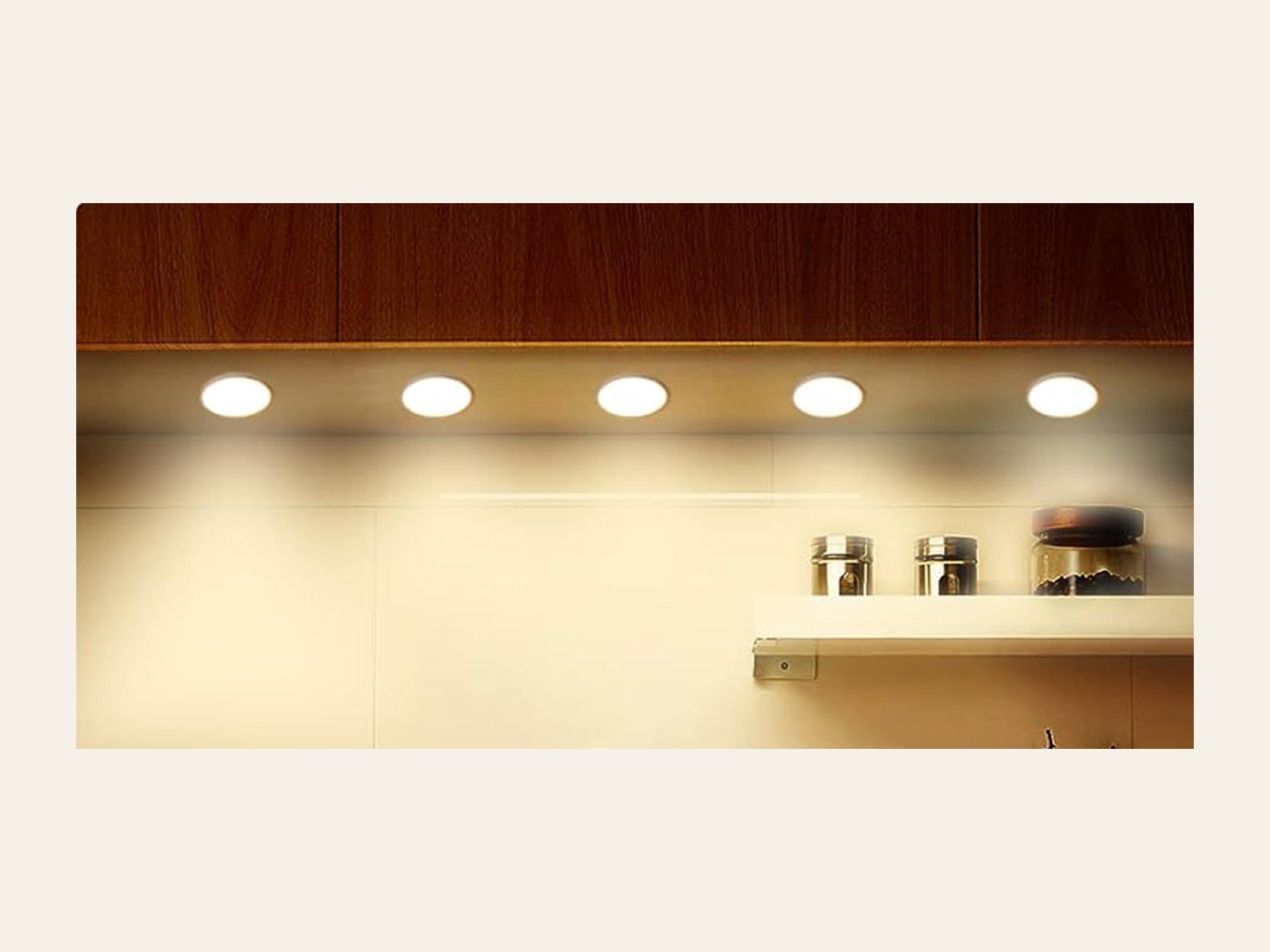 A dark room with a row of round night lights switched on, glowing cream under a dark ceiling.
