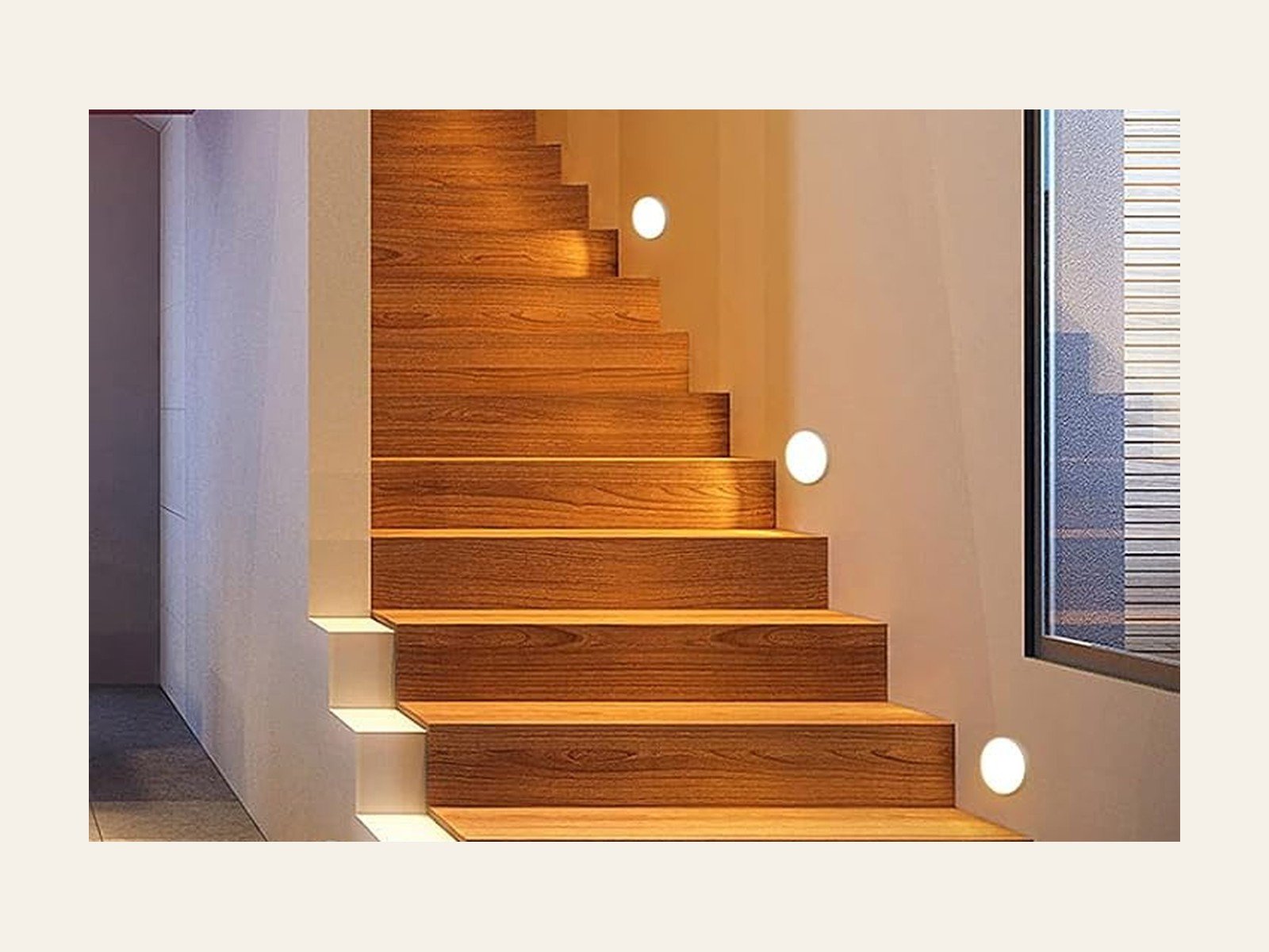 A stair at night, warm orange along the step, with a cooler grey wall beside it.